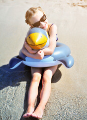 Wall Mural - Pretty girl has fun on beach with rubber duck