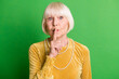 © deagreez - Photo of old lovely cute woman grandmother cover close lips mute silence isolated on green color background