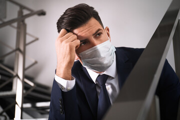 Canvas Print - Sad man in protective mask on stairs indoors. Self-isolation during coronavirus pandemic