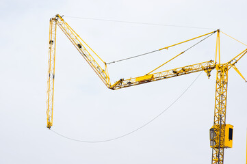 Arm of yellow tower crane fold up at construction site