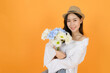 © Chanawin - Portrait of pretty cute young asian girl with casual white shirt and jeans feeling excited, on orange background