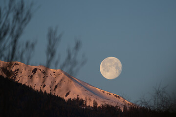 at sunrise on the mountains and the moon goes down