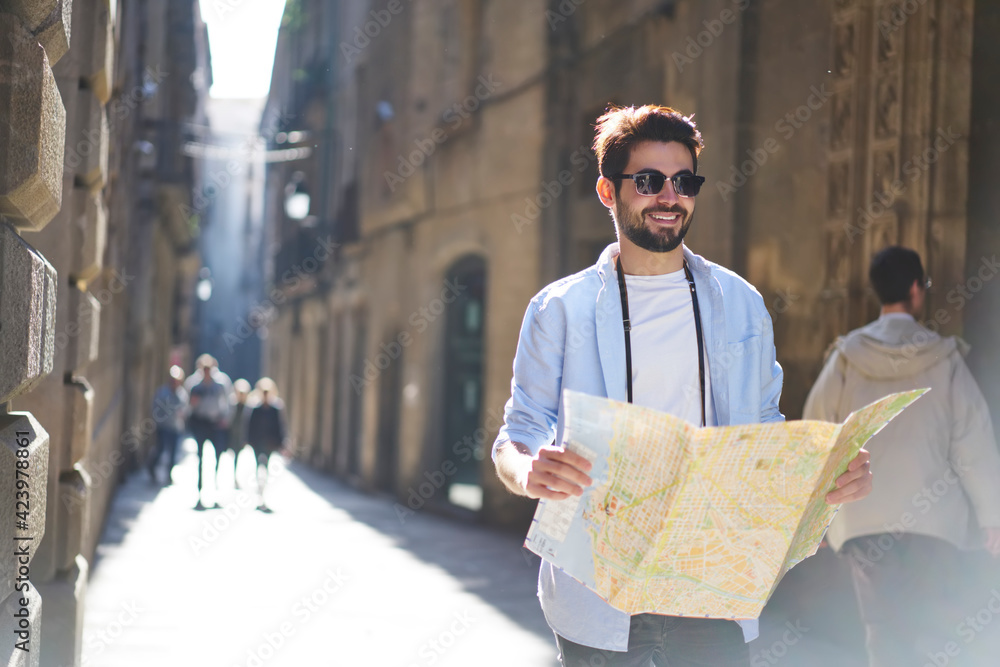 Happy man with map on street - obrazy, fototapety, plakaty 