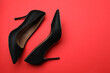 © New Africa - Pair of elegant black high heel shoes on red background, flat lay. Space for text