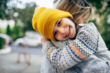 Candid Portrait Of A Happy Little Girl In The Yellow Hat Hugging Her Mom. Happy Kid Embracing Her Mother Enjoying The Time Together Outside. Joyful Mom And Daughter Share Love. Mother's Day