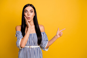 Wall Mural - Photo of sweet shocked young woman dressed off-shoulders dress pointing empty space arm cheek isolated yellow color background