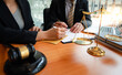 © PaeGAG - Businesswomen and lawyers discussing contract papers with brass scale on wooden desk in office. Law, legal services, advice, Justice concept