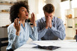 © JustLife - Young couple sitting in the kitchen preparing bills to pay. Stressed woman and man having financial problems