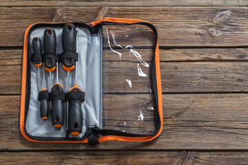 set of screwdrivers in case on dark wooden background