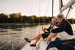 © Maskot - Happy senior couple using mobile phone during sunset