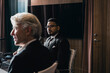© Maskot - Confident businessman sitting with senior male colleague in board room during meeting