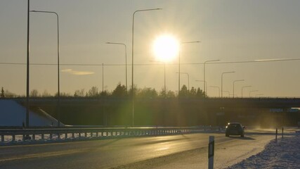 Wall Mural - The huge sun setting on the sky in the city with the cars passing by the road