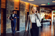 © Dusan Petkovic - Happy businesswoman on a business trip walking in the hall of the hotel and talking on the phone. Luxury, business, telecommunications, a business first,euphoria
