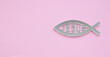 Christian sign of the fish. Gray fish with the word Jesus on a pink background, Christianity background with copy space