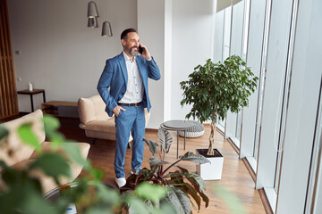 Wall Mural - Happy adult caucasian man is working in a modern office