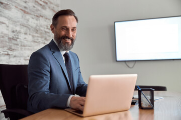 Happy adult caucasian man is working in a modern office