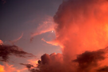 Crescent Moon Through A Bright Orange Cloudbank