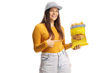 Female Teenager Holding A Pack Of Tortilla Chips And Pointing