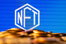 A NFT (non-fungible token) is a special cryptographically-generated token that uses blockchain technology to link with a unique digital asset. NFT symbol with coins in the foreground.