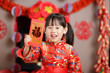 © M-image - Chinese young girl traditional dressing up with a 'FU' means ' lucky' red envelope