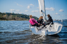 A Fast, Sporty, Single-masted Yacht With Three Athletes On Board Sails With A Fair Wind On A Beautiful River.