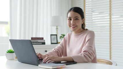 Wall Mural - Portrait headshot young attractive beautiful asia female sit on desk smile to camera work at home remotely computer laptop job. College student, employee feeling cozy happy in holiday weekend leisure.