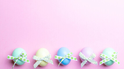 Wall Mural - Easter card. Colorful egg with tape ribbon on pastel pink background in Happy Easter decoration. Flat lay, top view with copy space.