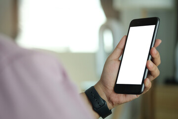 Wall Mural - close up view of man sitting on sofa and using mobile phone. blank screen for advertise text.