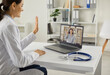 © Studio Romantic - Online doctor greeting female patient in an online video meeting. General practitioner waving hand at laptop saying hello to happy young woman. Telemedicine and modern virtual medical service concept