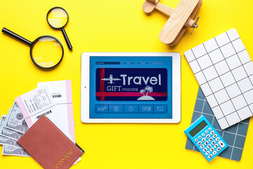 Sticker - Tablet computer with gift voucher and travel accessories on color background