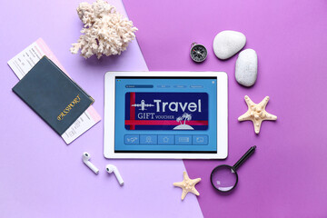 Sticker - Tablet computer with gift voucher and travel accessories on color background