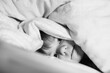 © Irina Schmidt - Little toddler girl having fun in bed after wake up. Healthy child jump and play hide and seek with parents. Adorable kid at home, family lifestyle.