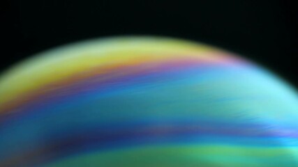 Sticker - Rotating colorful rainbow bubble on black background. Abstract backdrop