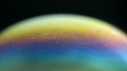 Sticker - Rotating colorful rainbow bubble on black background. Abstract backdrop