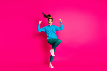 Sticker - Full size photo of delighted funny girl fists up raise knee open mouth scream celebrate isolated on pink color background