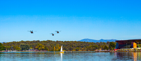 Black Hawk helicopters flying overhead at Lake Burley Griffin during an aerial fly over event in Canberra to mark 100 years of the Royal Australian Air Force