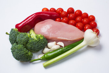 Raw chicken breast and vegetables, cherry tomatoes, garlic and peppers green and red