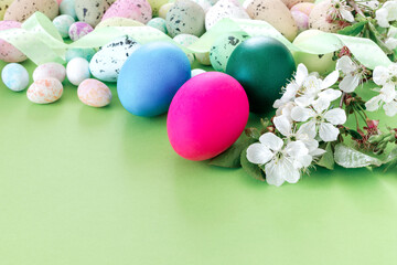  Beautiful Easter card with colorful eggs and cherry branches on paper green background.