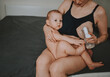 © Алина Троева - Young mother with newborn cute infant naked baby boy, holding him on arms, using breast pump hugging and breastfeeds with breast milk. Healthy child, concept of hospital and happy motherhood. Nursery.