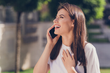 Wall Mural - profile photo of optimistic brunette lady talk telephone wear white cloth walking in park outside