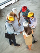 © BalanceFormCreative - Group of architects and engineers discuss about construction blueprint.High angle view.