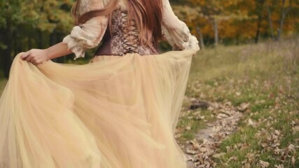 Wall Mural - Happy joyful beautiful young woman in a medieval dress is runing in forest, enjoying nature. Slow motion. brown beige vintage dress. Long red hair fly flutter in wind. Cheerful girl back rear view.