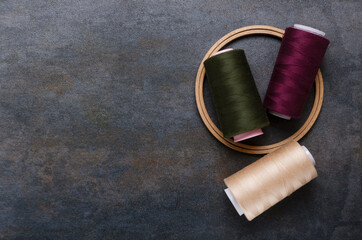 Wall Mural - Top view of round wooden frame and threads on the rustic grey surface.Empty space