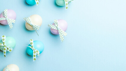 Wall Mural - Easter flat. Colorful egg with tape ribbon on pastel blue background in Happy Easter decoration. Spring holiday top view concept.