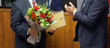Men in business suits - officials, businessmen, teachers or lawyers - participants in the awards ceremony. Presentation of a certificate of honor and a bouquet of flowers