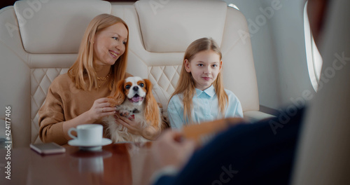 Wealthy family with dog travelling together by private business plane