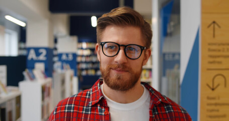 Canvas Print - close up of smiling hipster male student walking in library