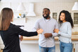 © Vadim Pastuh - Goal achievement concept. Happy African-American couple getting keys from own property from real estate agent. Multiracial newlyweds relocated, moving in new apartment