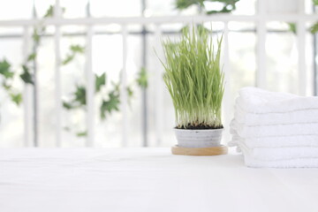 Towel placed on basket, white table top, bottle of liquid soap, spa set for bathing in the bathroom, copy space, bathroom window.