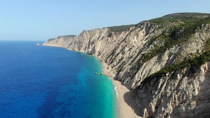 Poster - Aerial view of a beautiful deserted white sand beach surrounded by cliffs on Kefalonia, Greece. The drone flies backwards.